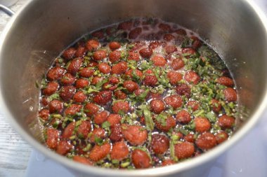 Reçeli kaynayana kadar ısıt, karıştırmaya gerek yok, sadece salla. Sıcaktan uzak tut, 5-6 saatliğine ayrıl ki böğürtlenler şurupla ıslansın..