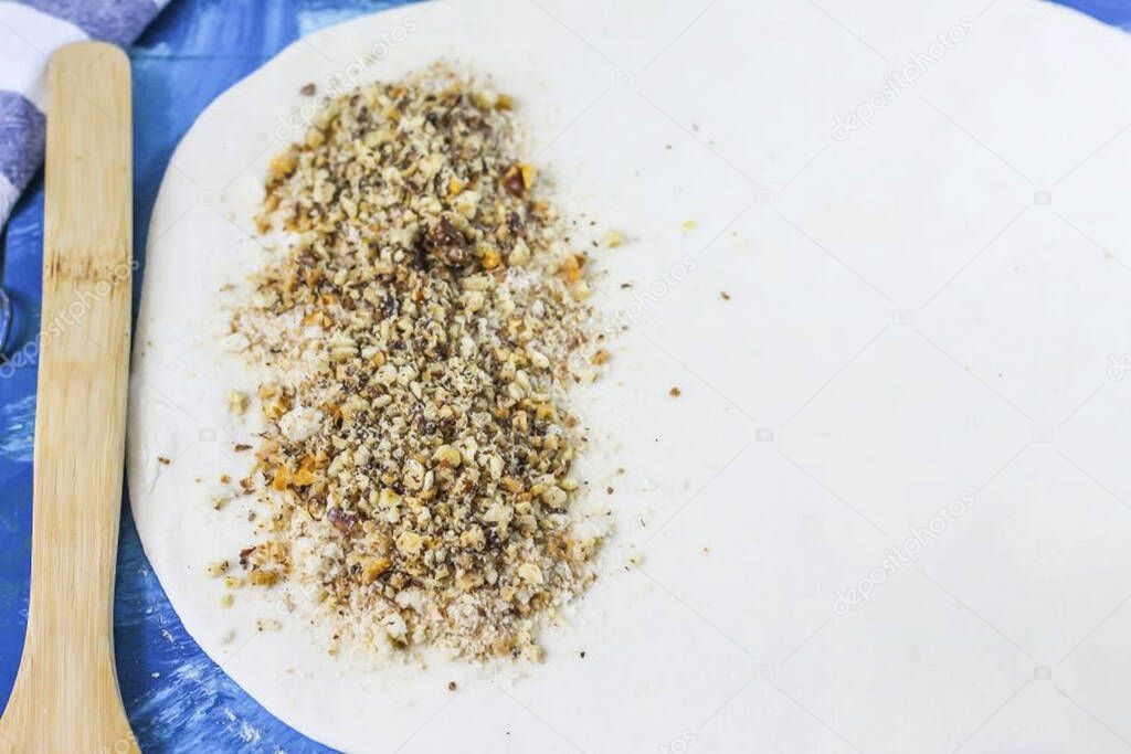 Roll out the puff pastry thinly on a work surface. Pour crackers on the edge, pour nut crumbs on top.