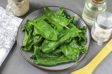 Bir demet ıspanağı parçalara ayır, her yaprağı suyla durula ve saplarını kes. Nemden kurtulmak ve tabağa koymak için kağıt havluya batır. Yeşilleri kaynar suyla haşlayabilirsiniz ya da ıspanağı kaynar suda 2-3 dakika kadar tutabilirsiniz.