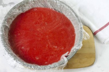 Kalıbı yapışkan bantla kapla ve çileği boşalt. 40-60 dakika dondurucuda bekletin..