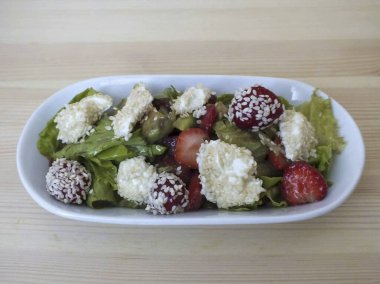 Bir dosyalama yöntemi seçin. Bireyleri daha çok seviyorum. Daha küçük bir salata kasesinde, tabanın bir kısmını yerleştirin, susamlı peyniri ekleyin ve çilek ekleyin..