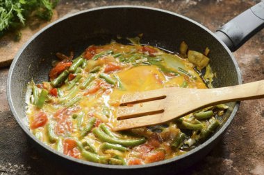 Bütün malzemeleri ahşap bir spatulayla karıştır, 5-7 dakika düşük ısıda pişir..