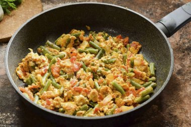 Bir süre sonra, yeşil fasulyeleri yumurta ve domatesle servis et..