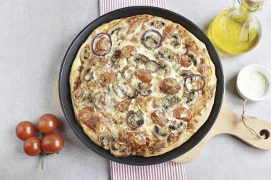 Fırında 15 dakika boyunca 270 dereceye kadar ısıtılmış pizza pişir. Fırınına göz kulak ol. Bitmiş pizzayı bir tahtaya koy ve bir süre beklet, tam anlamıyla birkaç dakika..