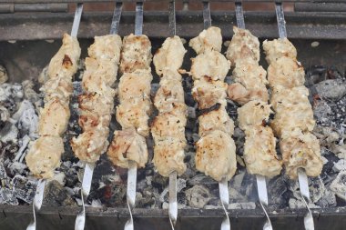 Salamura edilmiş eti şişlerin üzerine koy ve sıcak kömürleri koy. İyi kömür sağlanırsa, kebap 7-10 dakika içinde hazır olur..