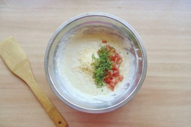 Domatesi ince ince doğra, tohumları ayır. Maydanozu doğra ve sert peyniri rendele..