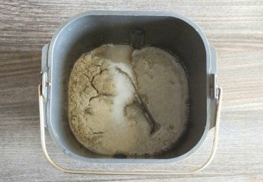 Ekmek makinesinin kovasına sıcak su dök. Aroaranth unu, maya ve şeker ekle..