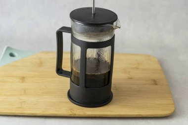 Fransız makinesine kahve dök, sıcak su ekle, üstünü ört ve 5 dakika demlenmeye bırak. Sonra yavaşça pompayı indir ve kahveyi filtrele..