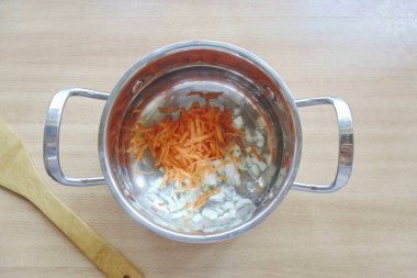 Havuçları rendele ve soğanı ince ince doğra. Bir tencere koy, ayçiçeği yağı dök ve soğanlar şeffaf olana kadar sebzeleri kızart..