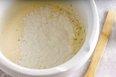 Tereyağını mikrodalgada eritip yumurta kütlesine kadar bir kaseye dök. Buğday unu ve kabartma tozu ekle. Fırını 180 dereceye ısıt. Kuru malzemeleri dikkatlice karıştır, hamurdan hava kabarcıkları çıkarmamaya dikkat et..