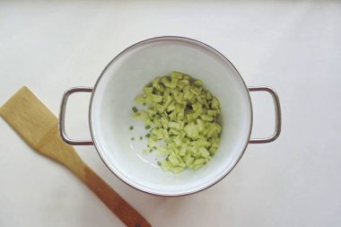 İnce doğranmış salatalık ekle. Eğer kabuk kalın değilse, o zaman salatalığı soyamazsın..