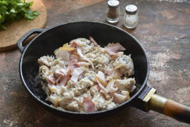 Kıyma balığını sebze yağıyla yağlanmış sıcak bir tavaya transfer et. Hemen doğranmış pastırma, tuz ve biber ekle. Fry, ara sıra 10-12 dakika boyunca kıpırda..