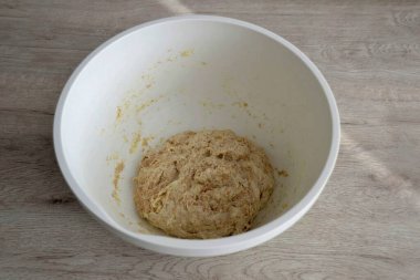 30-40 dakika sonra, kalan suyu dökün, hamuru yoğurun, sonra yoğurulmuş hamura tuz ekleyin ve tekrar yoğurun..