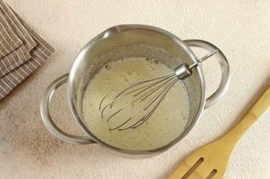 Yumurta ve şekeri tencerede çırp..