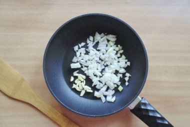 Soğanları soy, yıka ve ince ince doğra. Ayçiçeği yağlı bir tavaya koy.