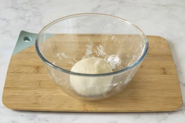 Hamuru 5-7 dakika kadar kıvır, sonra plastik sargıya sar ve 1 saat boyunca oda sıcaklığında ayrıl..