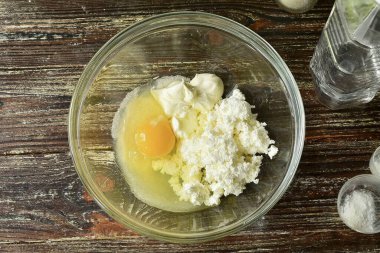 Yumurtayı bir kaseye koy, süzme peynir ve ekşi krema ekle..