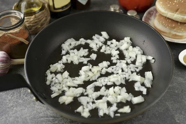 フライパンに少量の植物油を熱し 玉ねぎを入れ 小さなカップに切り刻み 3分間炒めます — ストック写真