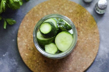 Kavanozu salatalıkla doldur ve birkaç kez salla ki salatalıklar birbirine daha yakın dursun..