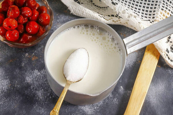 Налейте сливки в кастрюлю или котёл, положите контейнер на плиту и разогрейте, но не доводите до кипения. Температура крема должна быть около 80-90 градусов. Добавить сахар, ванильный сахар и тщательно перемешать.