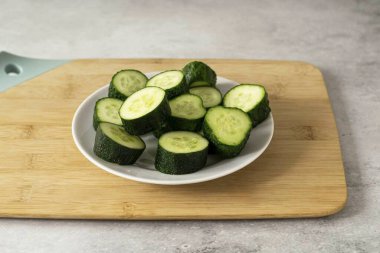 Salatalıkları 3-4 saat önce suya batır, sonra da yıkayıp dilimlere ayır. Eğer salatalıklar küçükse, onları tek parça bırakıp sadece uçlarını kesebilirsin..