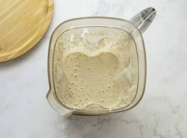 Krema için, kremaya benzeyen pürüzsüz bir kıvama gelene kadar suyu ve kaju fıstığını blender 'da öğütün. Sonra erimiş hindistan cevizi yağını ince bir dereye dökmeye başla ve kütleyi yenmeye devam et. Biraz daha kalınlaşana kadar bekle..