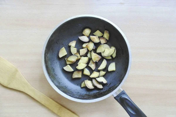 ジャガイモが沸騰している間 ナスを洗い ランダムに切り 野菜油でフライパンに入れます 断片を茶色に小さな部分でナスを炒める — ストック写真