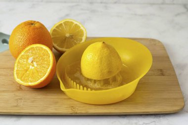 Bir portakal ve bir limon yıka, ikiye böl ve suyunu sıkıştır..