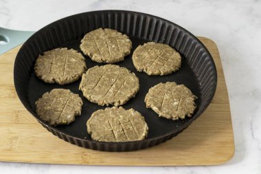 Hamurdan bir sosis çıkar, dilimlere böl ve her birini 5-6 mm 'lik bir kurabiye yap. Kurabiyeleri 15-17 dakika önceden 180 derece ısıtılmış bir fırında pişir..