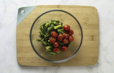 Sonra fırında domates ekle, mevsimi tuz ve biberle doldur ve yavaşça karıştır..