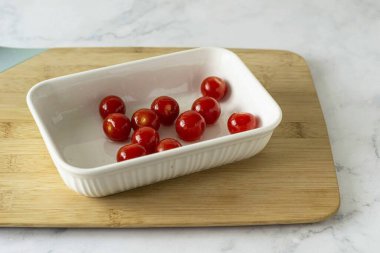 Zeytinyağıyla kiraz domatesleri serp ve 200 dereceye kadar ısıtılmış bir fırında 6-8 dakika pişir. Büyük domatesler ikiye bölünebilir..