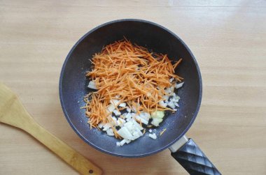 Havuçları dilimle, soğan ve sarımsağı ince ince doğra. Sebzeleri tavaya koy ve havuçlar yumuşayana ve soğanlar temizlenene kadar sote yap..