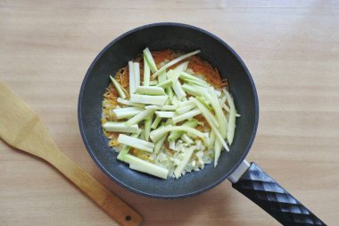 Sonra doğranmış dolmalık biber ve kabak ekle. İhaleye kadar sebze kaynat.