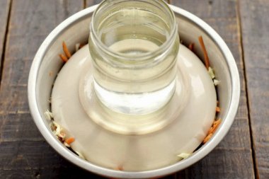 Karışımı düz bir plakayla kaplayın, baskıyı üste koyun. Bir kavanoz su baskı için uygundur. Lahanayı 3 saatliğine oda sıcaklığında mayalamaya bırak..