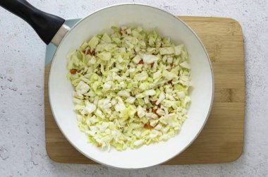 Genç beyaz lahanaları küp küp doğra. Diğer sebzelerle kaplanmış olarak, 7-8 dakika kadar, ihale açılana kadar. Lahananın yapışmasını önlemek için birkaç çorba kaşığı su ekleyebilirsiniz..