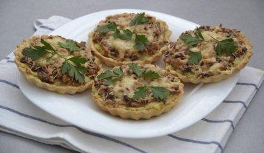 Kalıplardan tartları kaldırın, otlarla servis edin ve süsleyin. Hem sıcak hem de soğukturlar..