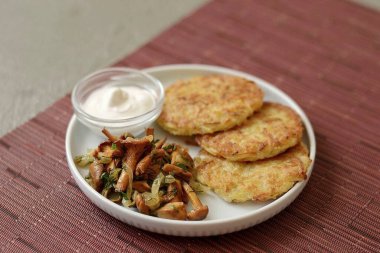 Kızarmış mantarları ve patatesli gözlemeleri bir tabağa koy..