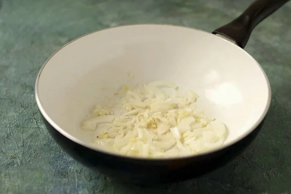 洋葱切成两半 大蒜切成细片 在锅里煎至软软 — 图库照片