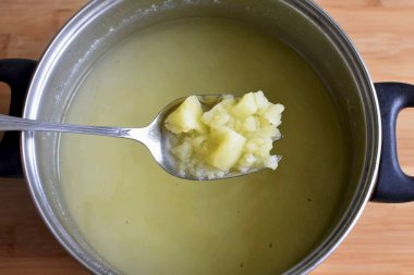 Mantarlar pişerken, patatesleri kaynatın. Bir buçuk litreden fazla su almayın. Kaba bir şekilde bitmiş patatesleri et suyunda ez..