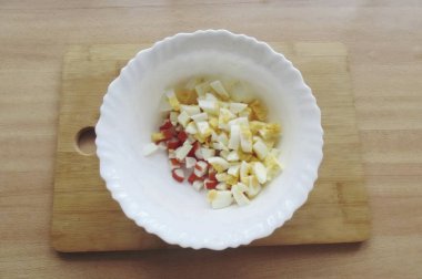 Sert haşlanmış yumurta, soğuk ve soyulmuş. Güzelce doğra ve salataya ekle..