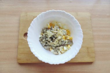 Kızarmış istiridye mantarlarını soğanlı salata kasesine koy..