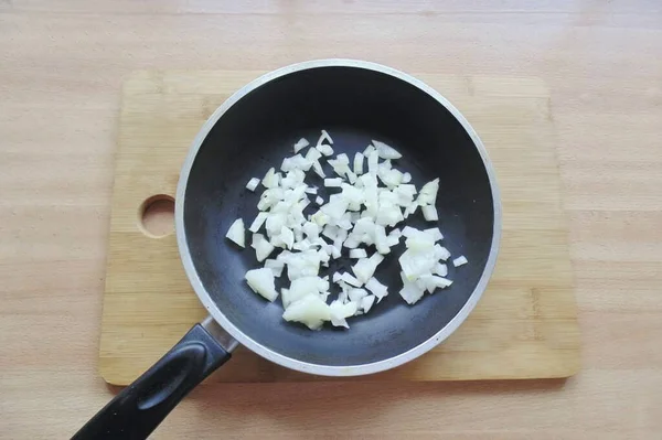 Soğanları soy, yıka ve ince ince doğra. Bir tavaya yerleştir.