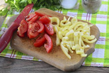 Çekirdekteki dolmalıkları soy. Çan biberi ve domatesleri şeritlere ayır..