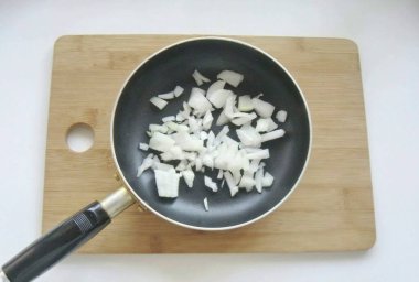 Soğanları soy, yıka ve ince ince doğra. Bir tavaya yerleştir.