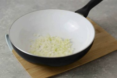 Tavada, doğranmış soğanları yarı pişene kadar soteler.