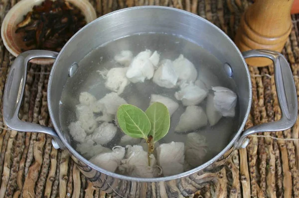 Tencereye su dök ve tavuk filetosunu parçalara ayır. Sivilceyi kaynat, köpüğü çıkar. Sonra, defne yaprağı ve tuz ekle. 20 dakika yemek pişir..