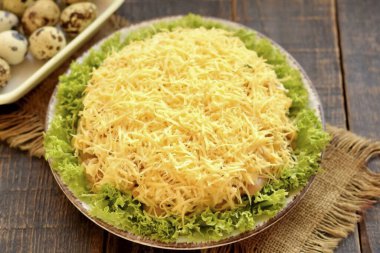 Sert peyniri rende rendele, salatanın üstüne serp. Üstüne bir mayonez ağı yap. Salatayı katmanları yıkamak için 30 dakikalığına buzdolabına koy..