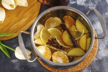 Sıcak su dök ve konteynırı ocağın üzerine koy. Tarçın, karanfil, yıldız anason ve tüm baharatları ekle.