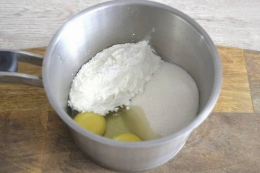 Krem sürerek eklerleri hazırlamaya başla. Bunu yapmak için, 2 yumurta, 150 gram şeker, mısır nişastasını bir tencereye koy, karıştır..