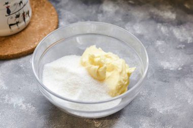 Tereyağını margarinle değiştirme! Buzdolabındaki yağı önceden çıkarıp yumuşatmak için zaman ver. Yağı sıvı hale getirmek için ısıtmaya gerek yok, ona yumuşak bir durumda ihtiyacımız var. Tereyağına şeker ve vanilya şekeri ekle.